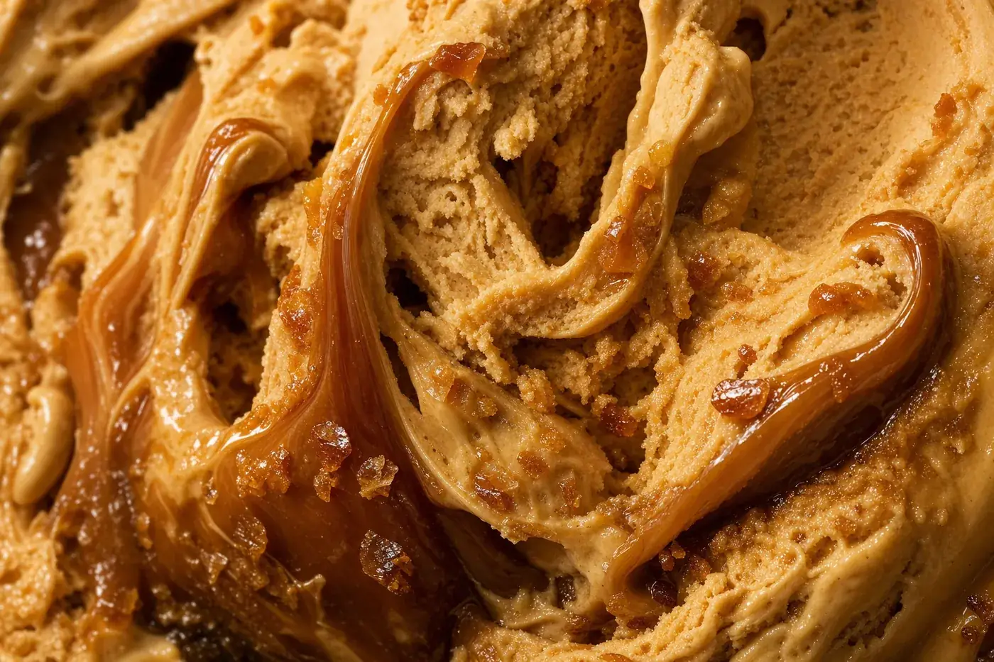 Macro close-up of dulce de leche gelato with thick caramel running through the churned ridges.